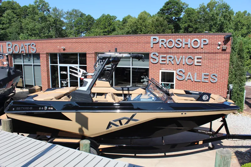 Slide: The Image of 2025 ATX Surf Boats 22 Type-S displayed outside a pro shop with service and sales signage. - 5