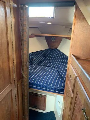 Slide: The Image of 1985 Catalina 30 sailboat interior with striped cushions and wooden cabinetry. - 6