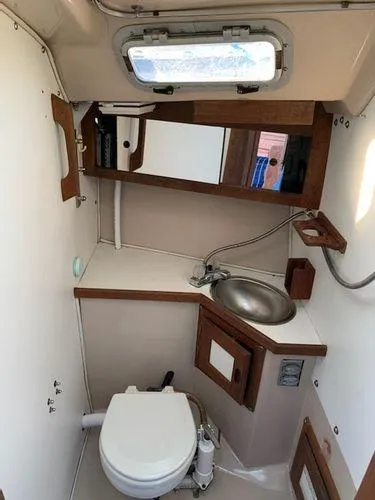 Slide: The Image of 1985 Catalina 30 sailboat bathroom with sink, toilet, and mirror. - 8