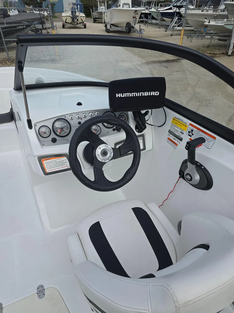Slide: The Image of 2021 Tahoe 450 TF boat cockpit with steering wheel and Humminbird navigation system. - 11
