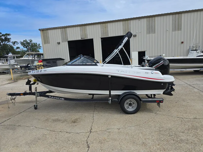 Slide: The Image of 2021 Tahoe 450 TF boat on trailer, parked outside a warehouse. - 3
