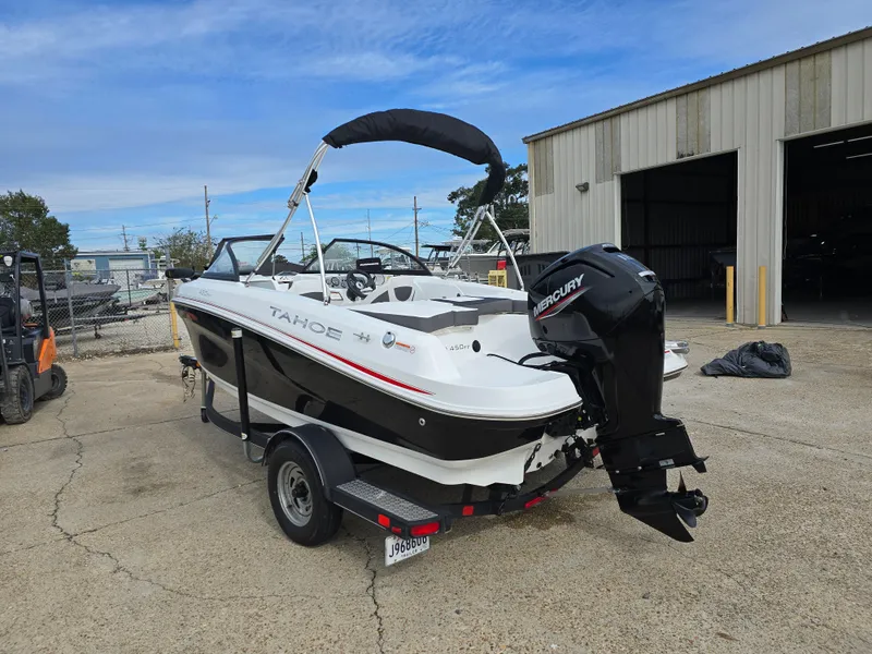 Slide: The Image of 2021 Tahoe 450 TF boat on trailer, parked outside a warehouse. - 4