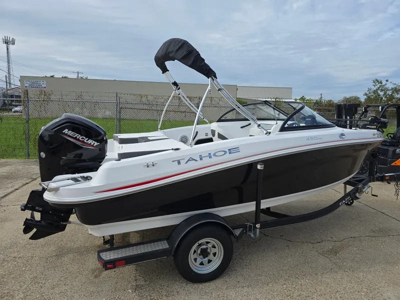 Slide: The Image of 2021 Tahoe 450 TF boat with Mercury engine on trailer, parked outdoors. - 7