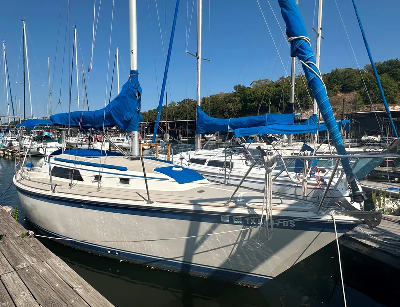 The Image of 1983 O'Day 28 sailboat docked at marina with blue sails. - 0