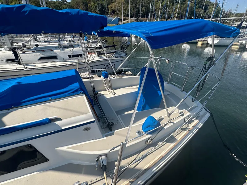 Slide: The Image of 1983 O'Day 28 sailboat with blue canopy docked at marina. - 2