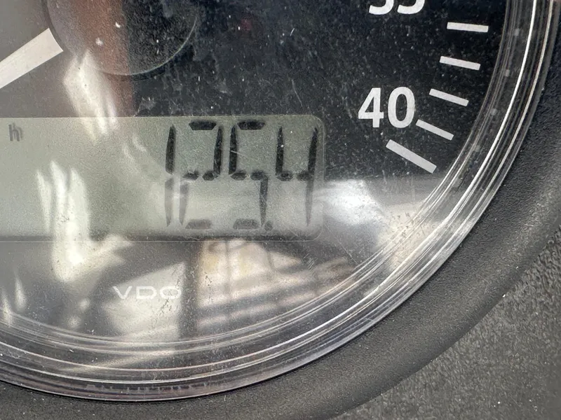 Slide: The Image of Close-up of a VDO gauge displaying 1254 hours on an O'Day 28, 1983 model. - 27