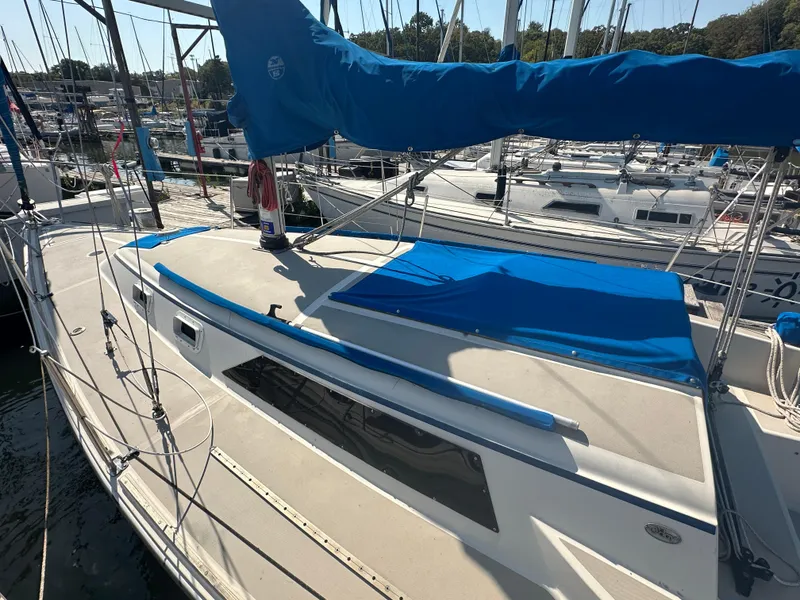 Slide: The Image of 1983 O'Day 28 sailboat docked, featuring blue sail cover and clean deck. - 3