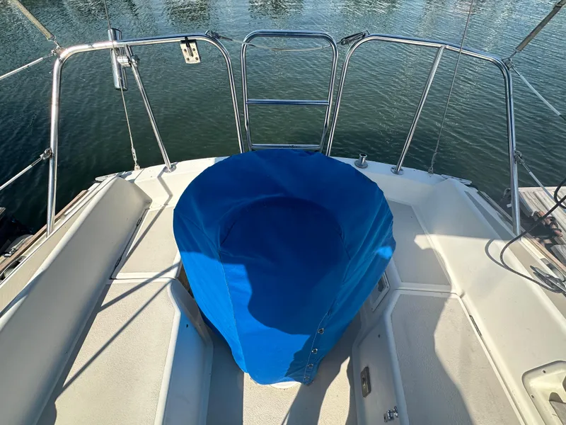 Slide: The Image of 1983 O'Day 28 sailboat cockpit with blue cover, docked on calm water. - 4