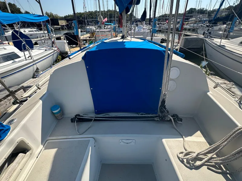Slide: The Image of 1983 O'Day 28 sailboat cockpit with blue cover, docked among other boats. - 5