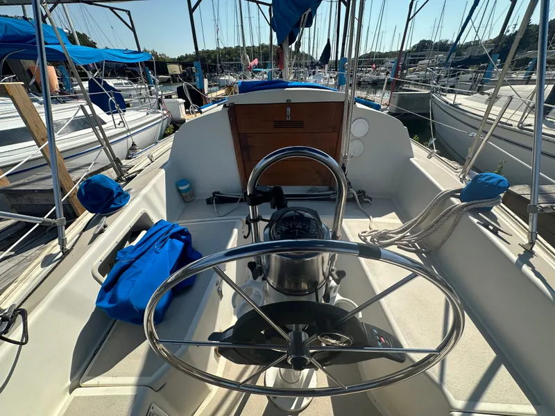Slide: The Image of 1983 O'Day 28 sailboat cockpit with steering wheel, docked in marina. - 8
