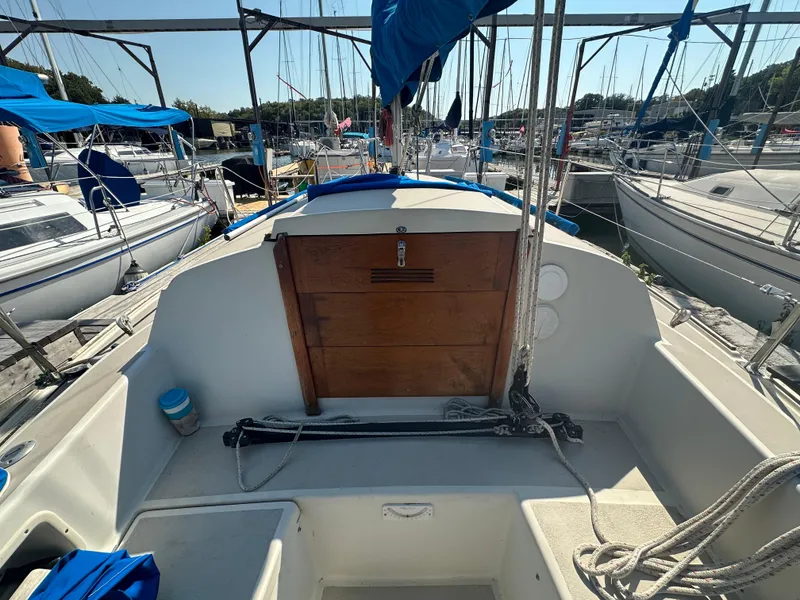 Slide: The Image of 1983 O'Day 28 sailboat cockpit with wooden hatch, docked in marina. - 9