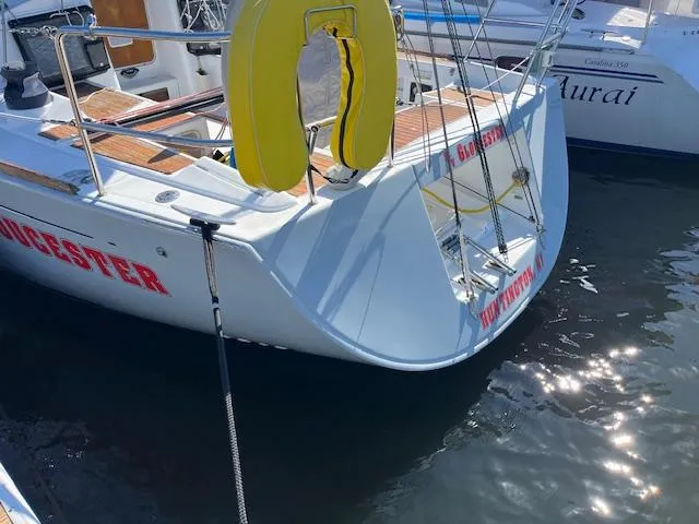 Slide: The Image of Beneteau First 36.7 sailboat, 2007 model, docked with visible life preserver and water reflections. - 10