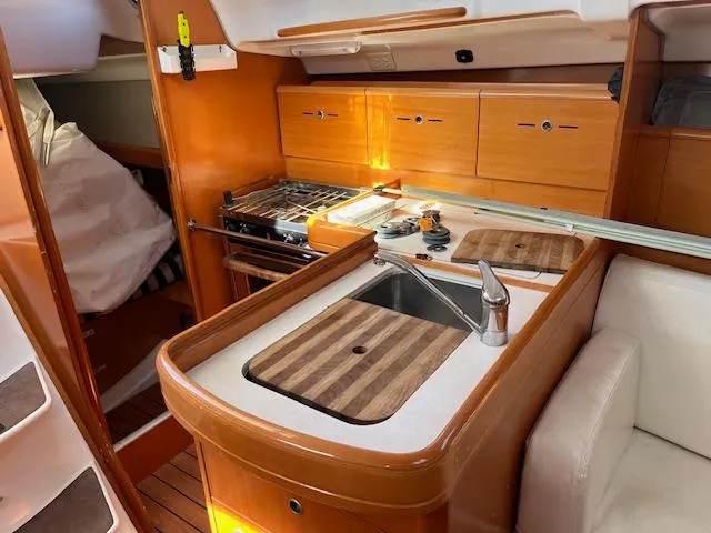 Slide: The Image of 2007 Beneteau First 36.7 yacht interior with kitchen, sink, and wooden cabinetry. - 24