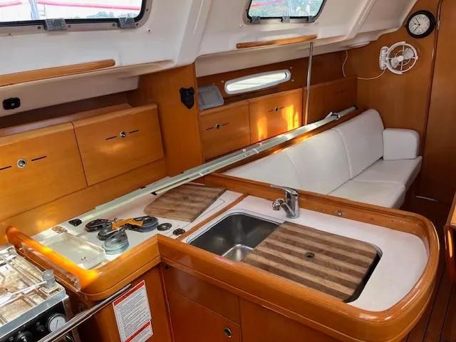 Slide: The Image of Interior of 2007 Beneteau First 36.7 sailboat with wood finish and compact kitchen area. - 3