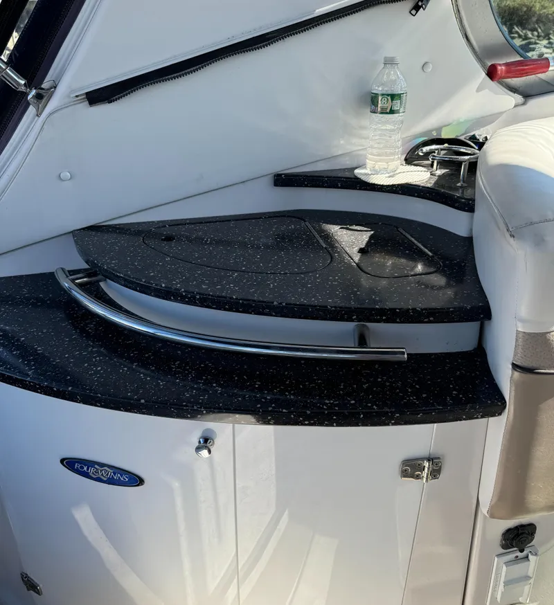 Slide: The Image of 2007 Four Winns 318 Vista boat interior with sleek black countertop and water bottle. - 10