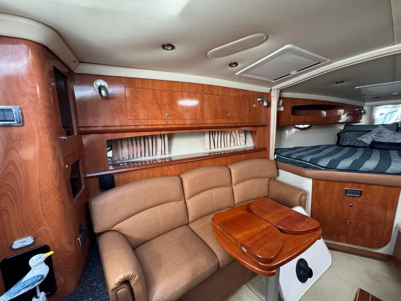 Slide: The Image of 2007 Four Winns 318 Vista cabin interior with wood finish, sofa, and bed. - 14