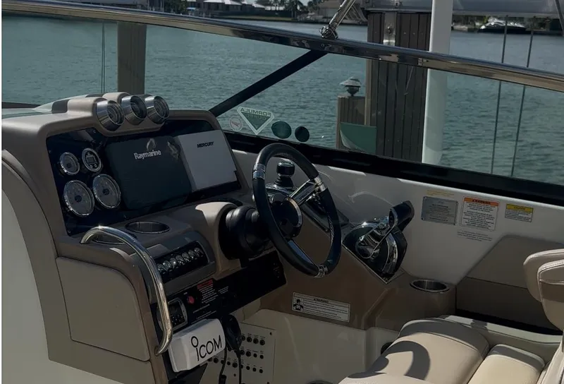 Slide: The Image of 2015 Formula 310 Bowrider cockpit with steering wheel and control panel, dockside view. - 10