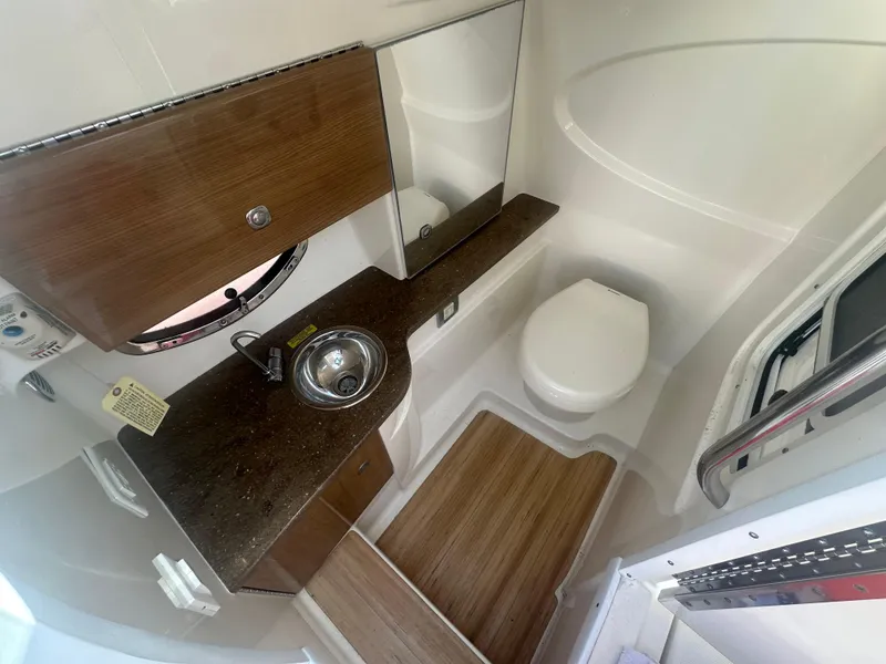 Slide: The Image of 2015 Formula 310 Bowrider bathroom with sink, toilet, and wood accents. - 17