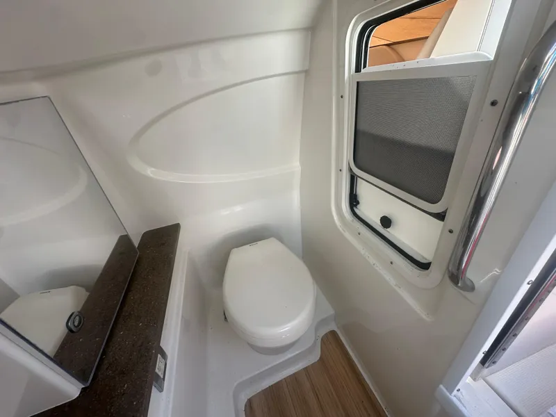 Slide: The Image of 2015 Formula 310 Bowrider bathroom interior with toilet and window. - 18