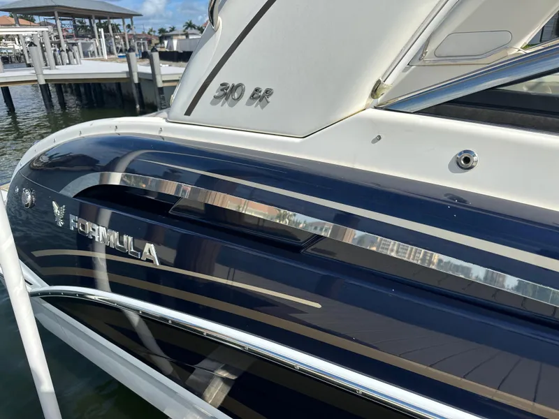 Slide: The Image of 2015 Formula 310 Bowrider boat docked, showcasing sleek design and branding. - 4