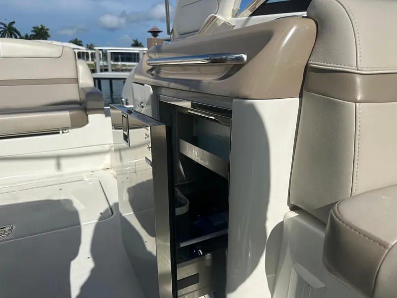 Slide: The Image of 2015 Formula 310 Bowrider interior with open storage compartment, beige seating, and sleek design. - 7