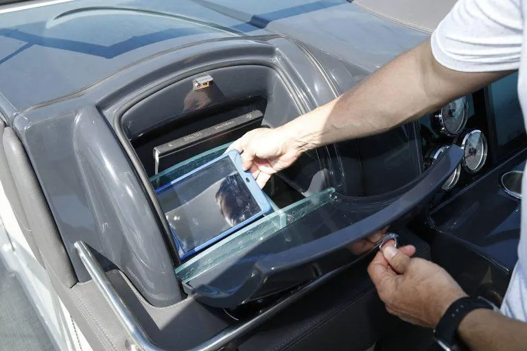 Slide: The Image of Person using storage compartment on 2025 Formula 350 CBR boat dashboard. - 13
