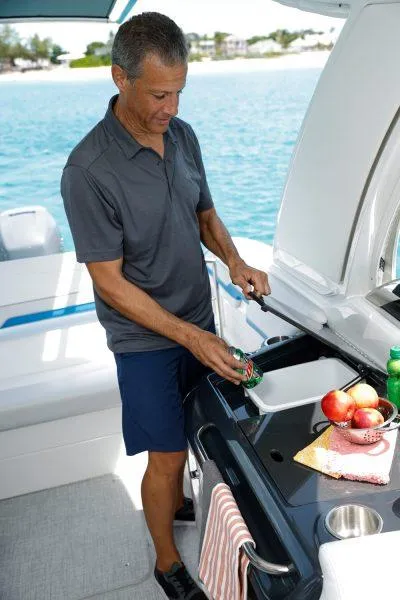 Slide: The Image of Man using sink on 2025 Formula 350 CBR boat, with fruit and towel nearby. - 17