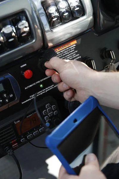 Slide: The Image of Close-up of a hand operating controls on a 2025 Formula 350 CBR boat dashboard. - 32