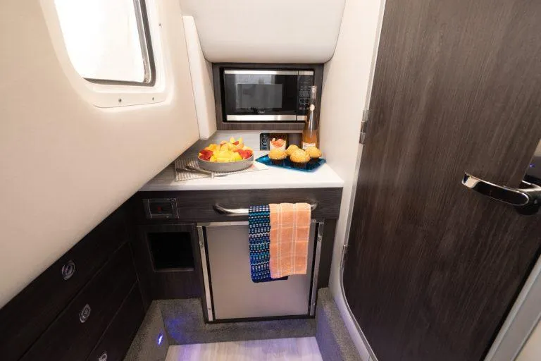Slide: The Image of 2025 Formula 350 CBR cabin kitchenette with microwave, fridge, and snacks. - 46