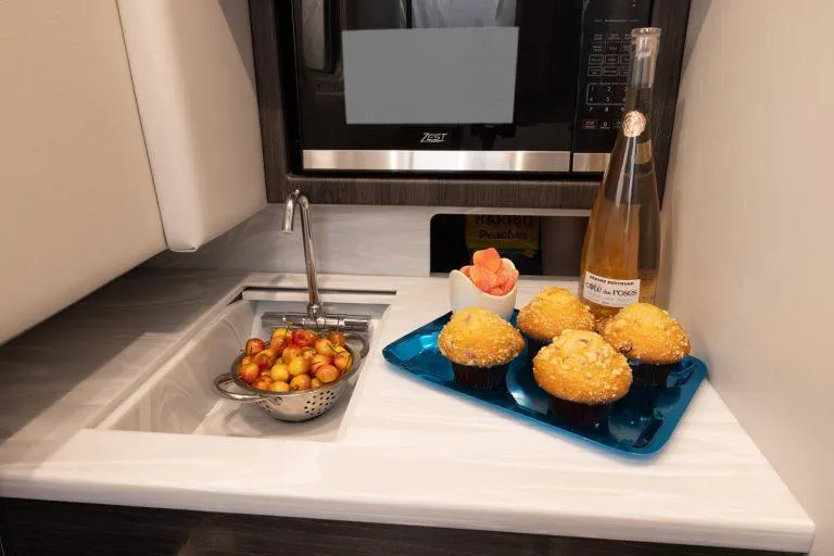 Slide: The Image of Compact kitchen area in 2025 Formula 350 CBR with muffins, fruit, and wine. - 47
