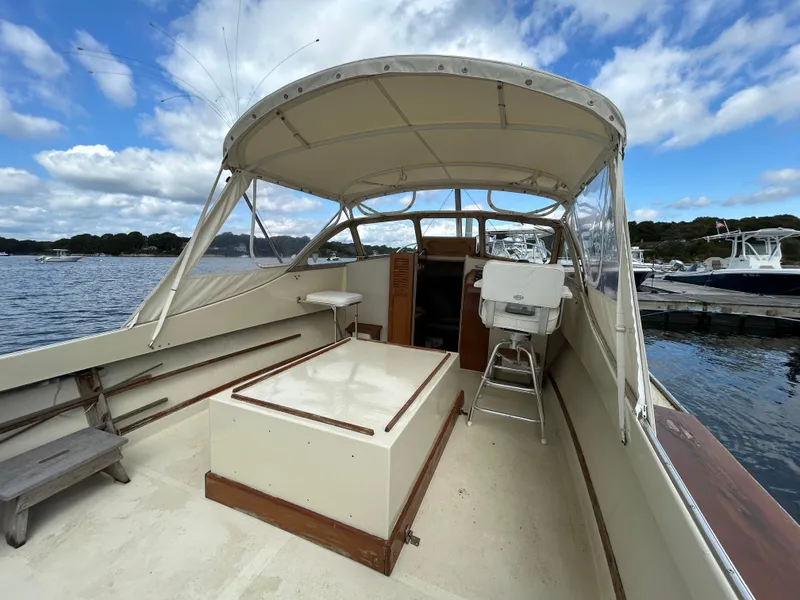 Slide: The Image of 1983 Fortier 26 boat interior with canopy, docked on a scenic lake. - 13