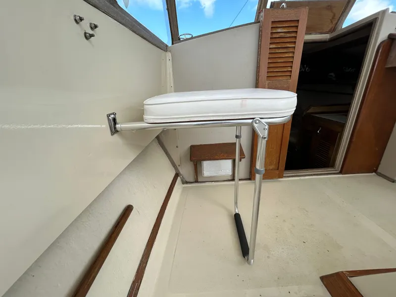 Slide: The Image of 1983 Fortier 26 boat interior with foldable seat and wooden accents. - 16
