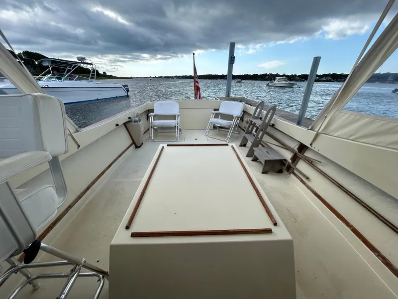 Slide: The Image of 1983 Fortier 26 boat interior with seating, docked on a cloudy day. - 17