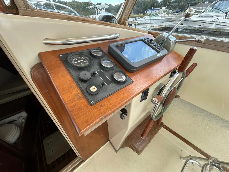 Slide: The Image of 1983 Fortier 26 boat helm with wooden dashboard and navigation instruments. - 19