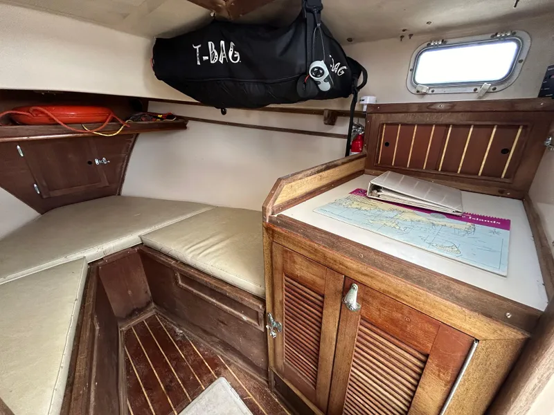 Slide: The Image of Cozy cabin interior of 1983 Fortier 26 boat with map and storage. - 27