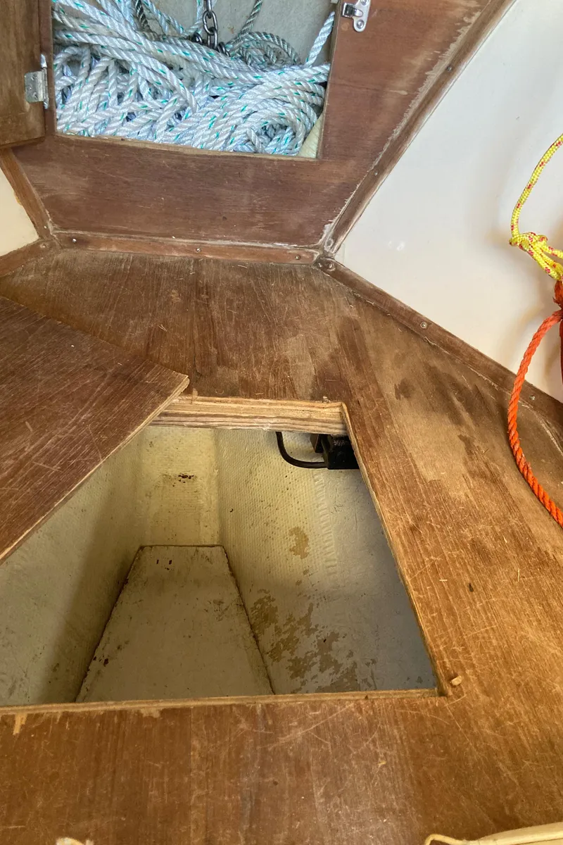 Slide: The Image of 1983 Fortier 26 boat interior with open wooden hatch and visible storage compartment. - 30