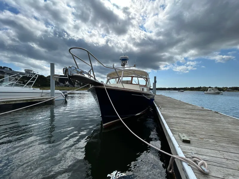Slide: The Image of 1983 Fortier 26 boat docked at marina under cloudy sky. - 39