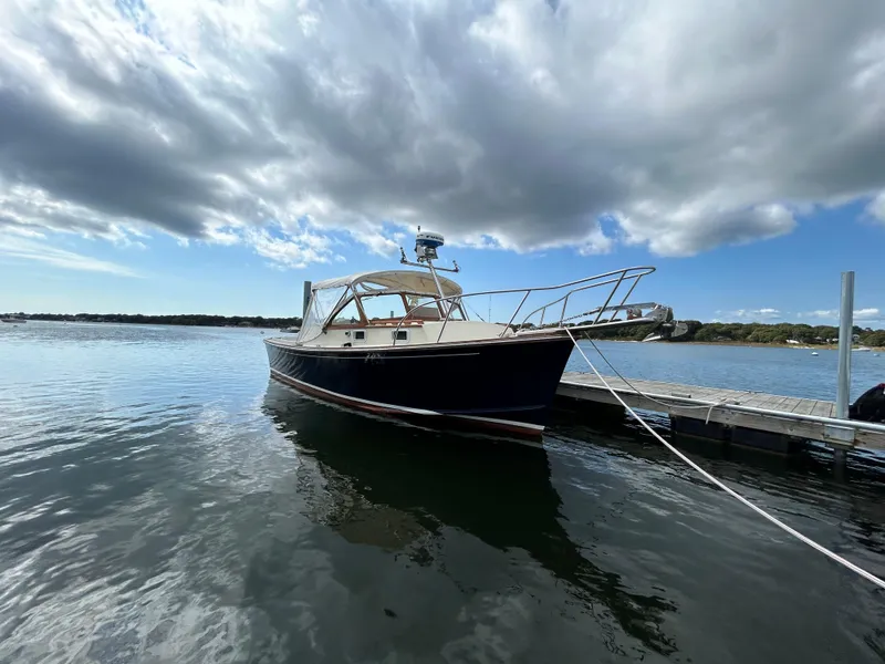 Slide: The Image of 1983 Fortier 26 boat docked on calm water under cloudy sky. - 41