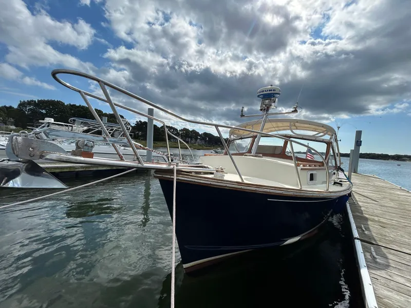 Slide: The Image of 1983 Fortier 26 boat docked under a partly cloudy sky. - 43