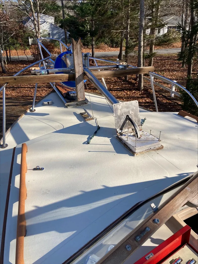 Slide: The Image of 1983 Fortier 26 boat deck with wooden railings and anchor, surrounded by trees. - 45