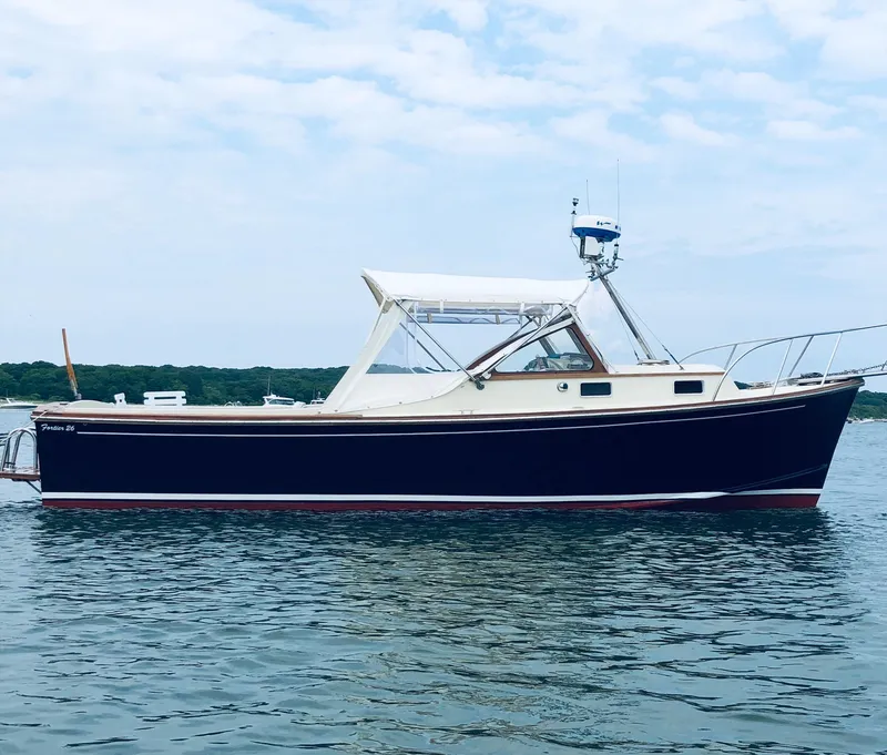 Slide: The Image of 1983 Fortier 26 boat on calm water under a partly cloudy sky. - 46