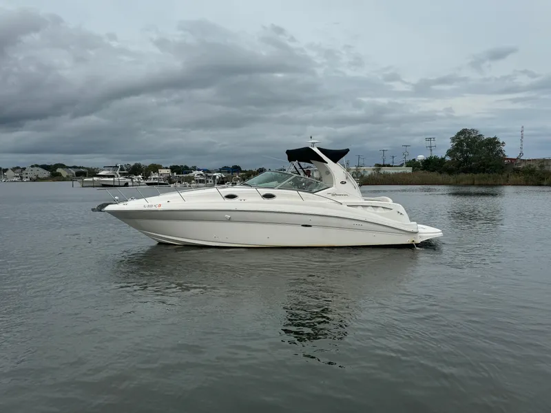 Slide: The Image of 2003 Sea Ray 320 Sundancer yacht on calm water under cloudy sky. - 10