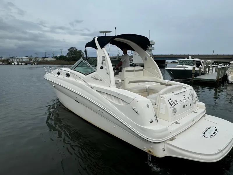 Slide: The Image of 2003 Sea Ray 320 Sundancer boat docked on calm water. - 16