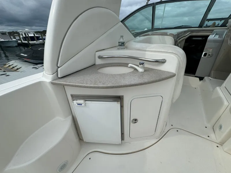 Slide: The Image of 2003 Sea Ray 320 Sundancer boat interior with sink and mini fridge. - 18