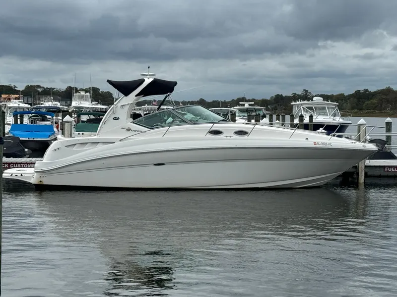 Slide: The Image of 2003 Sea Ray 320 Sundancer yacht docked at marina under cloudy skies. - 2