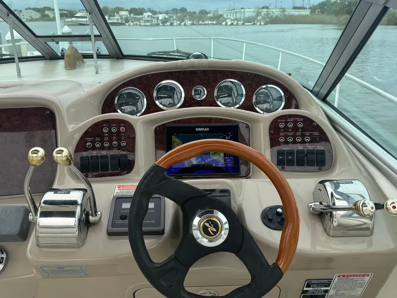 Slide: The Image of Dashboard of a 2003 Sea Ray 320 Sundancer boat with steering wheel and controls. - 22