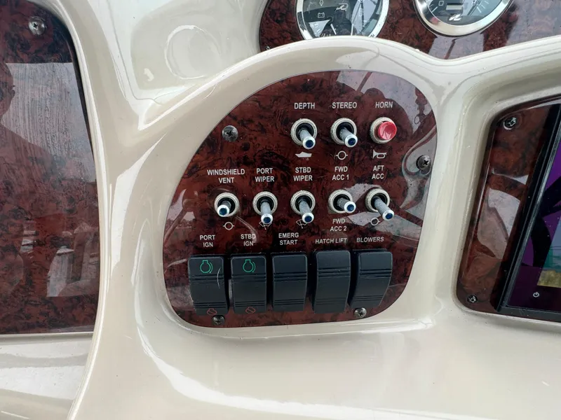 Slide: The Image of Control panel of a 2003 Sea Ray 320 Sundancer boat with various switches and dials. - 29