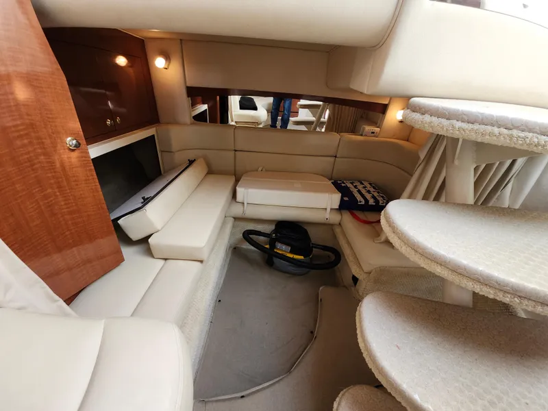 Slide: The Image of 2003 Sea Ray 320 Sundancer cabin interior with beige seating and wooden accents. - 33
