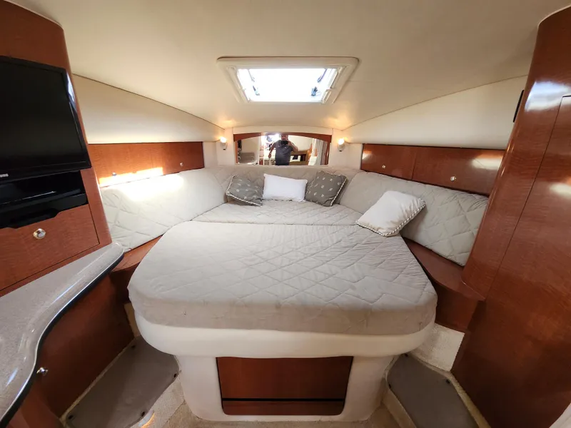 Slide: The Image of Interior cabin of 2003 Sea Ray 320 Sundancer with cozy bed and wooden accents. - 35