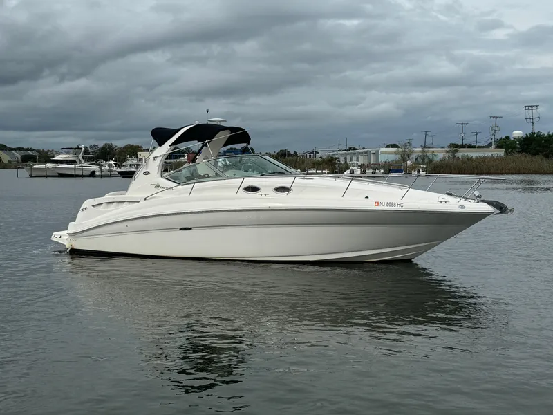 Slide: The Image of 2003 Sea Ray 320 Sundancer boat on calm water under cloudy skies. - 4